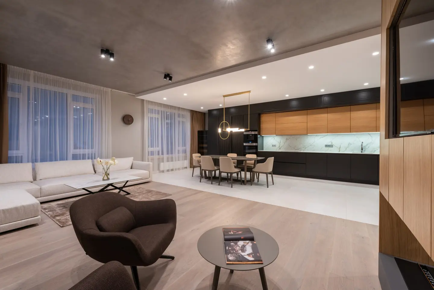 Interior residencial con salón, comedor y cocina abierta en tonos naturales